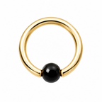 A minimalist gold ring with a smooth, polished black spherical bead set into the front, photographed on a clean white background.