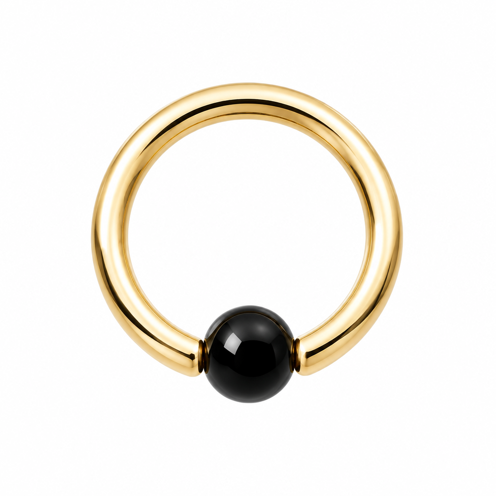 A minimalist gold ring with a smooth, polished black spherical bead set into the front, photographed on a clean white background.